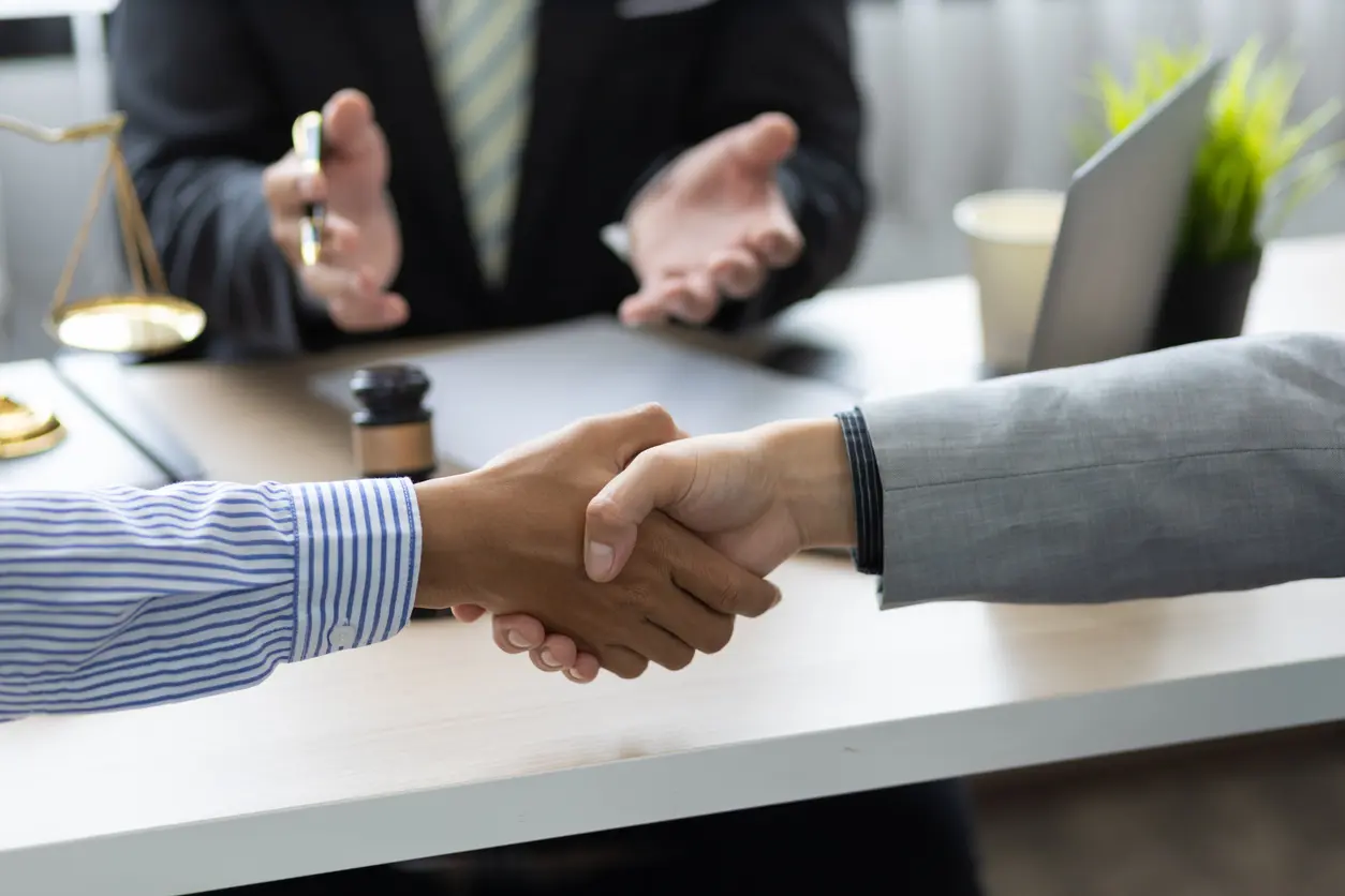 two people shaking hands infront of a mediator during a personal injury lawsuit in colorado