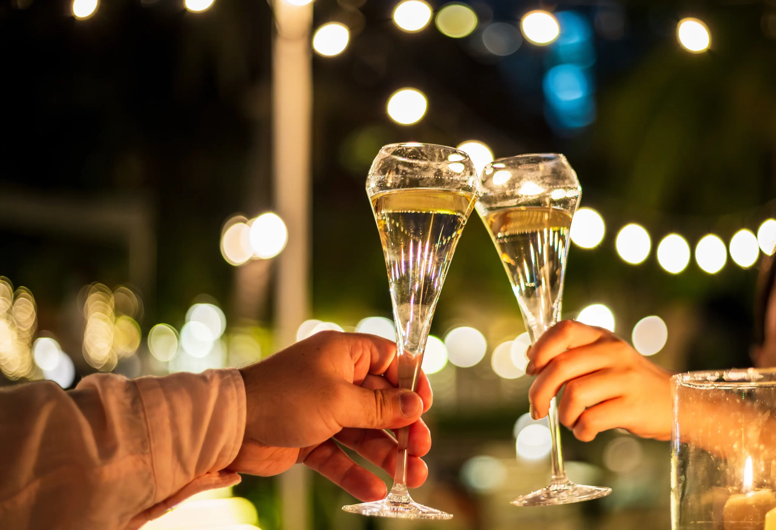 two people clinking drinks