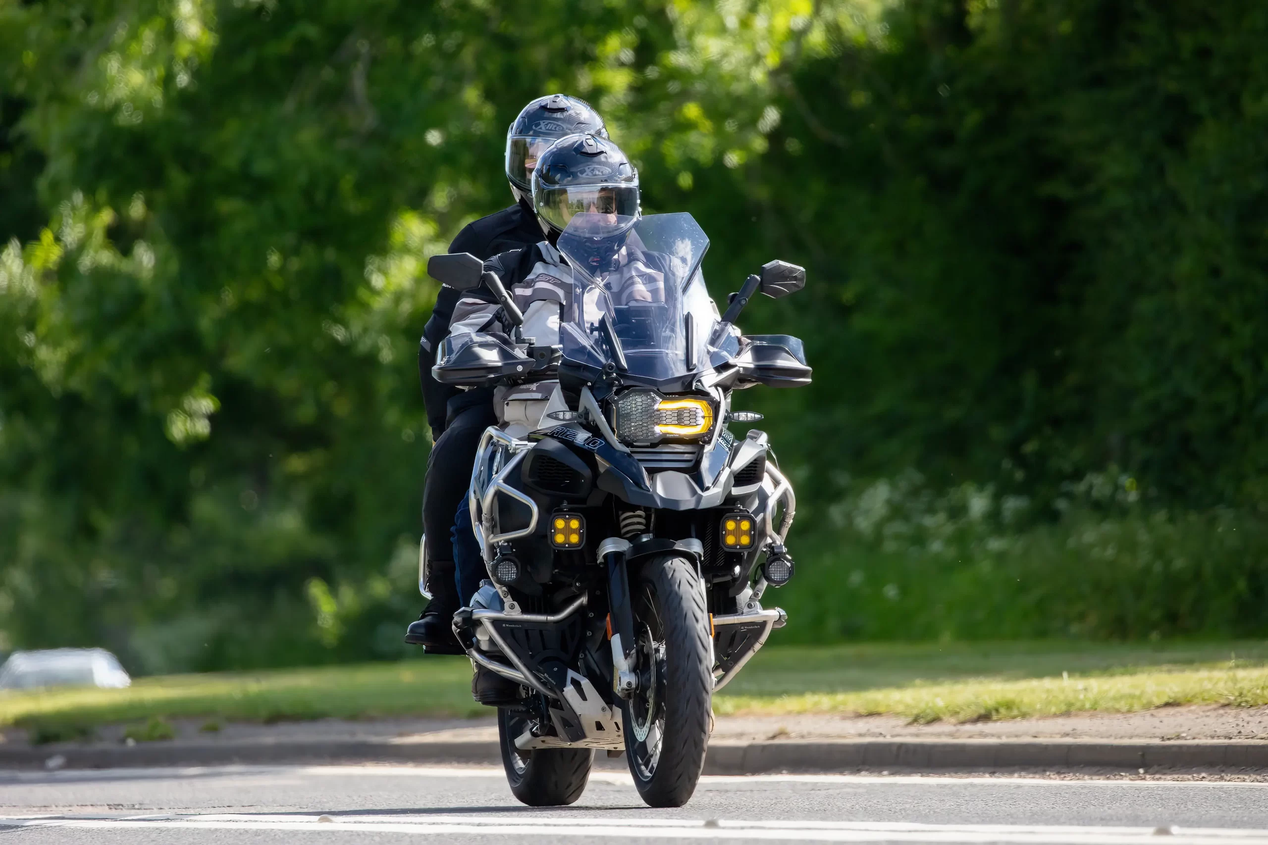 Motorcycle riders with a passenger riding behind them