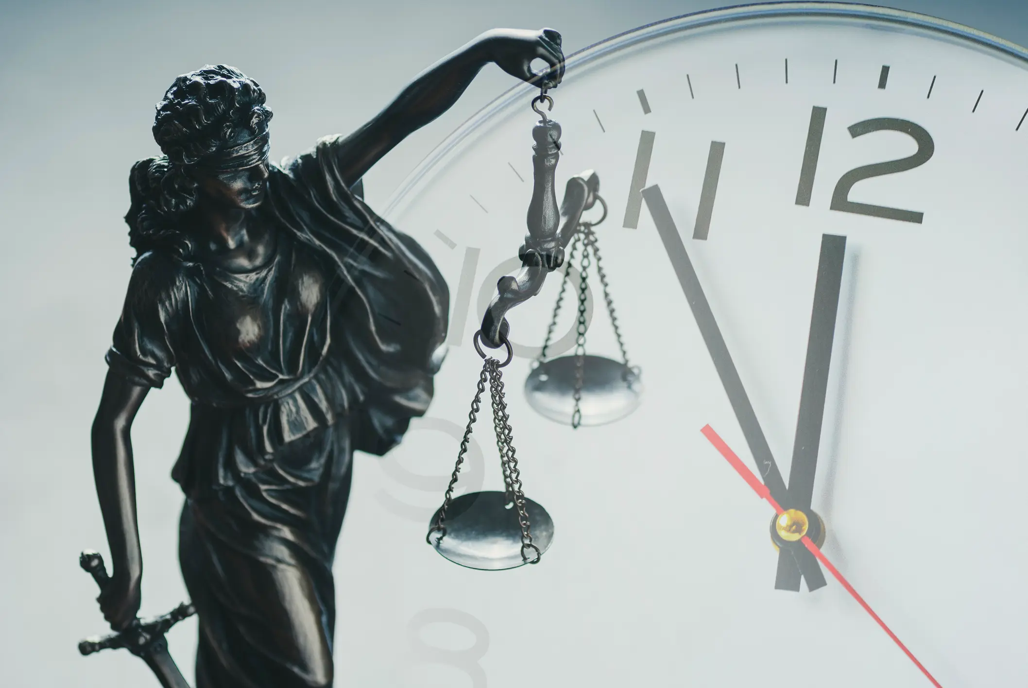 lady of justice with her scales infront of a clock. Representing the statue of limitations on car accident claims