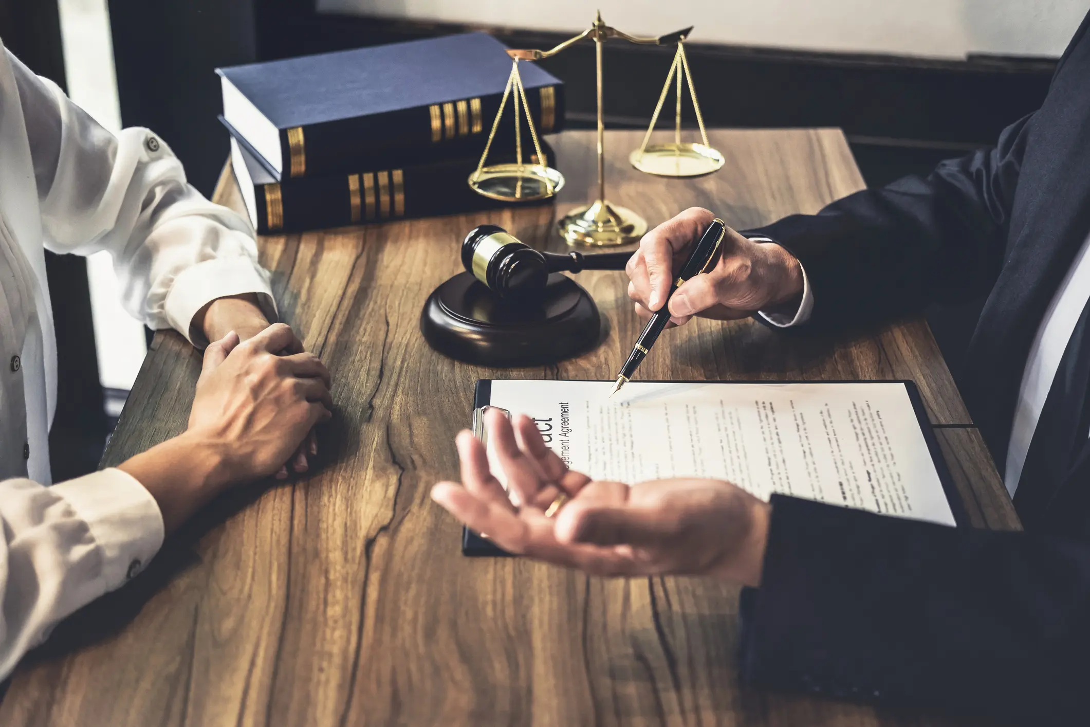 an estate planning attorney discussing matters with a client while sitting at a wooden desk