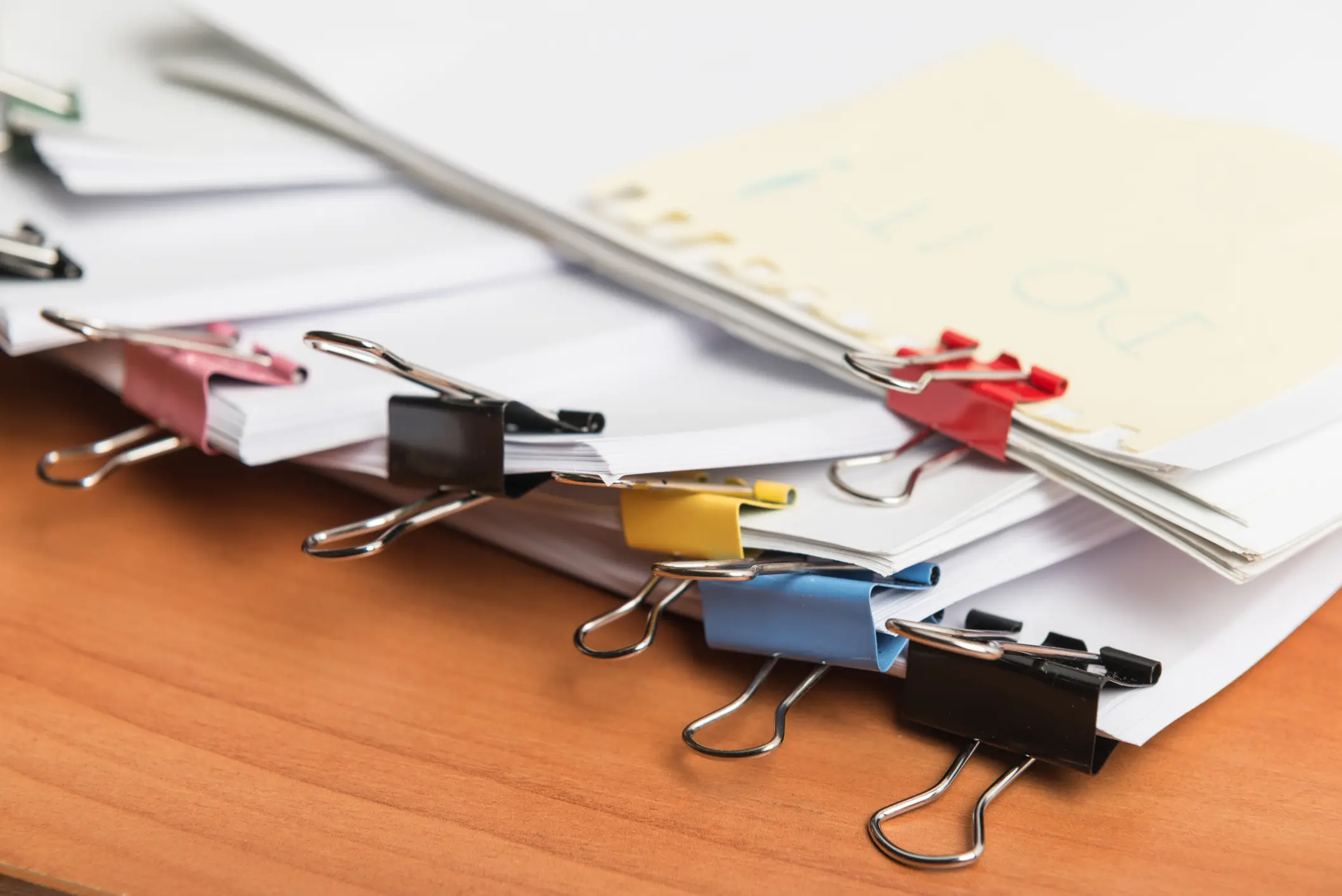 papers on a desk being held together by paper clips