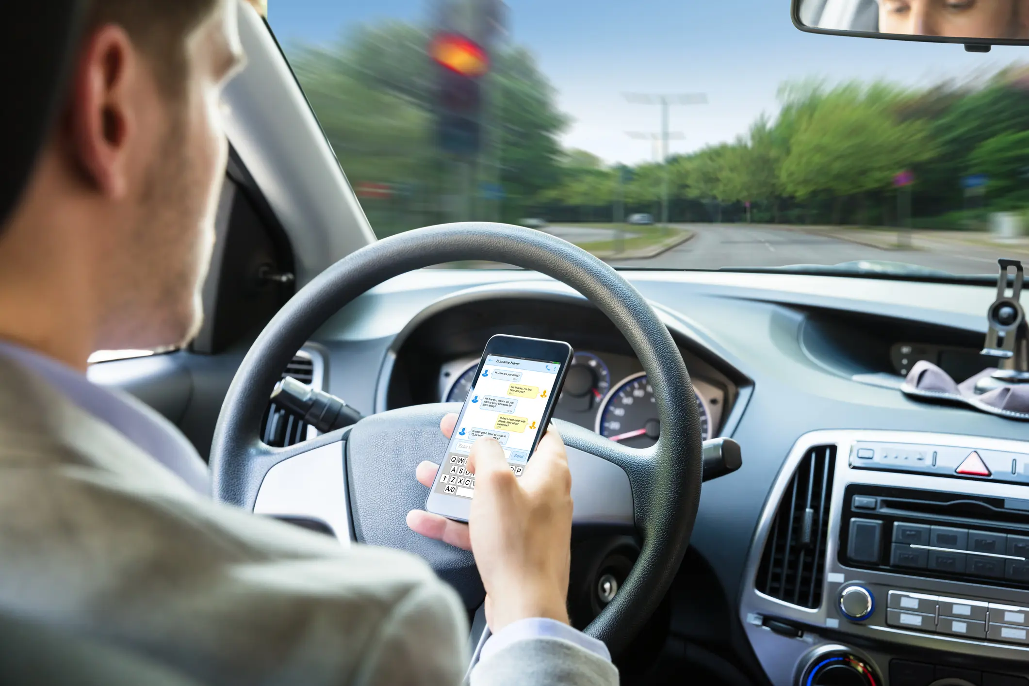 Man texting while driving in car.