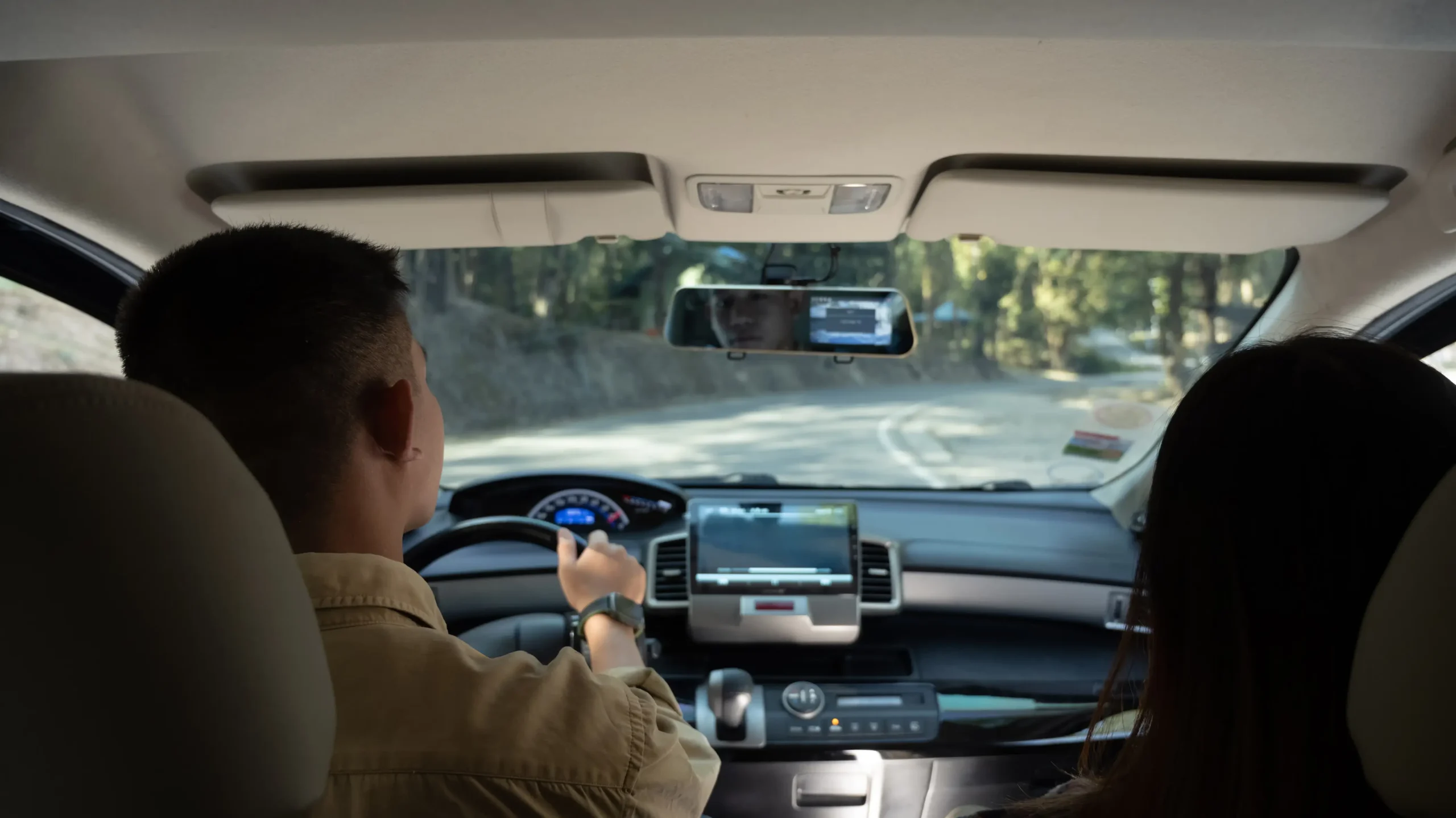 man and women driving in a car with a data box inside it