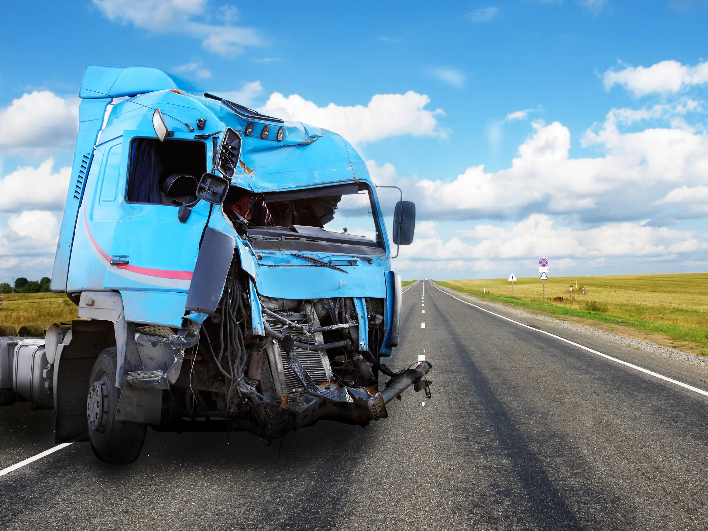 a semi truck smashed up on the side of the road